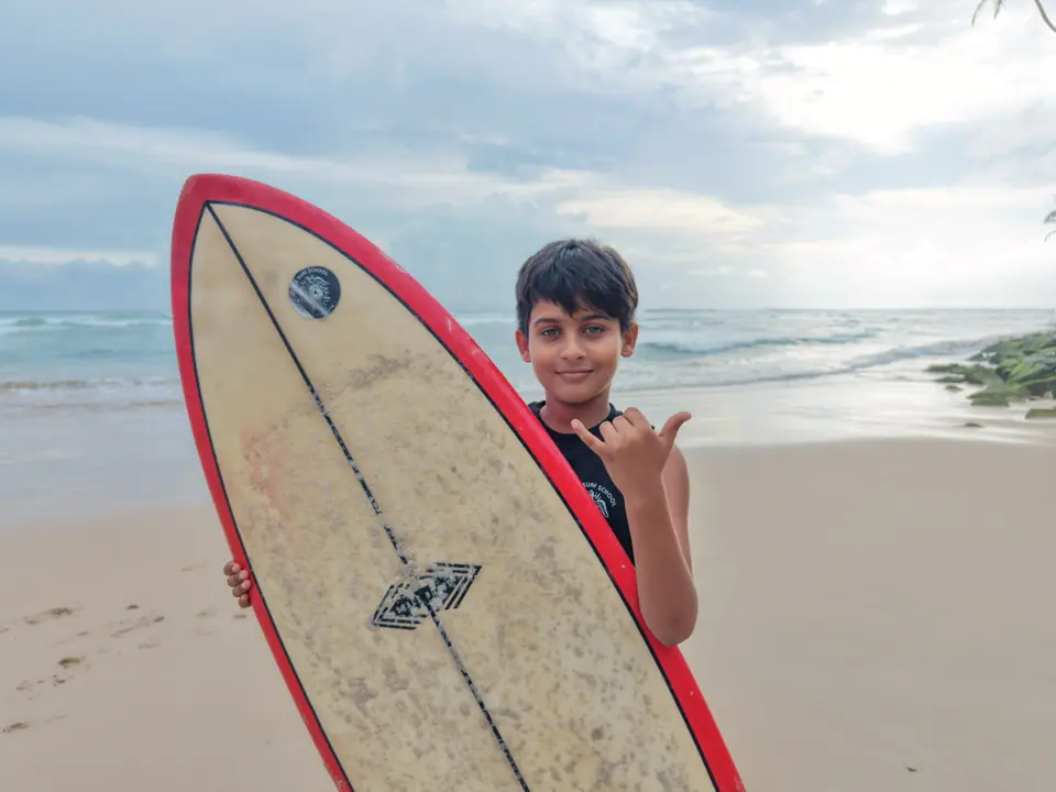 Ashen with his surfboard on Kabalana Beach
