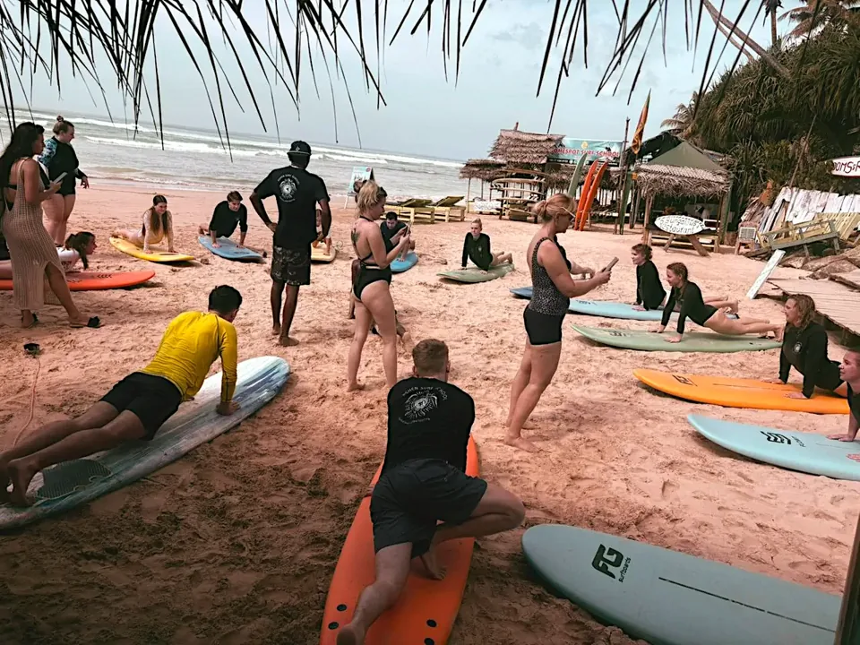 Friends practise surfing together on Kabalana Beach