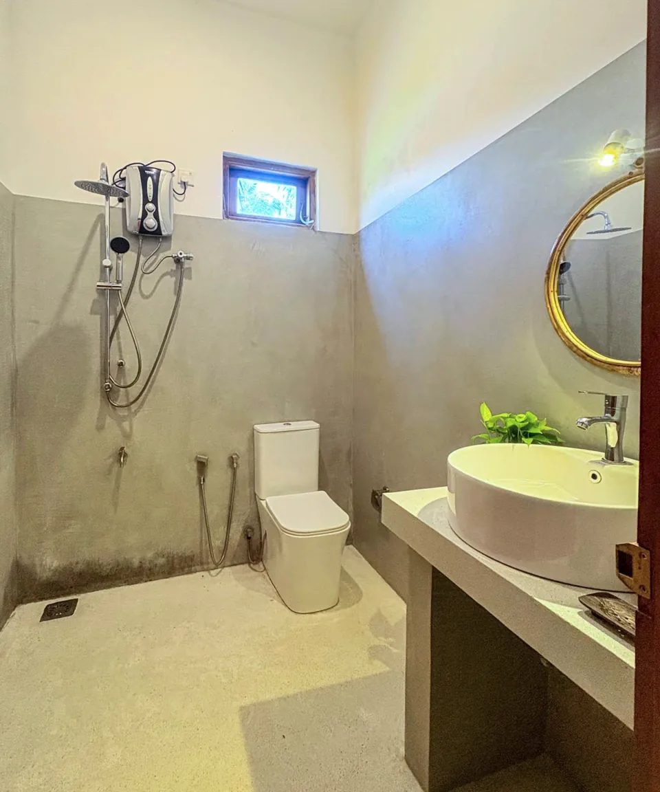 Bathroom with a shower, toilet and sink at Ashen Surf House