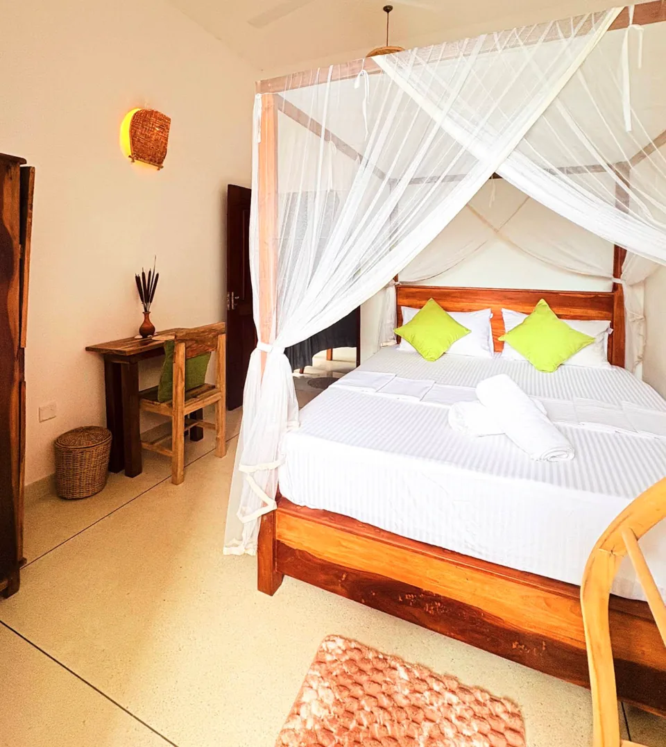 Double-bed room with a mosquito net at Ashen Surf House