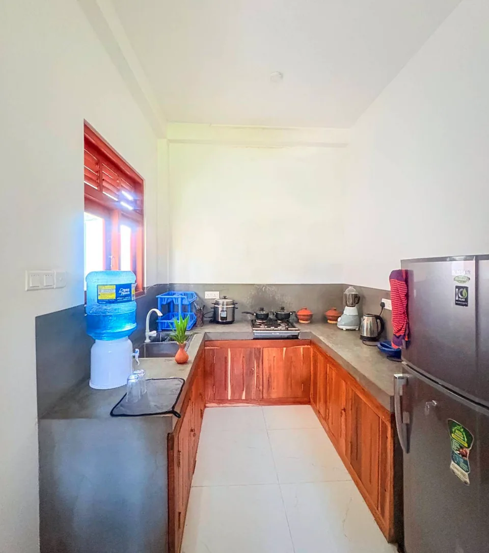Kitchen with wooden cupboards and a refrigerator at Ashen Surf House